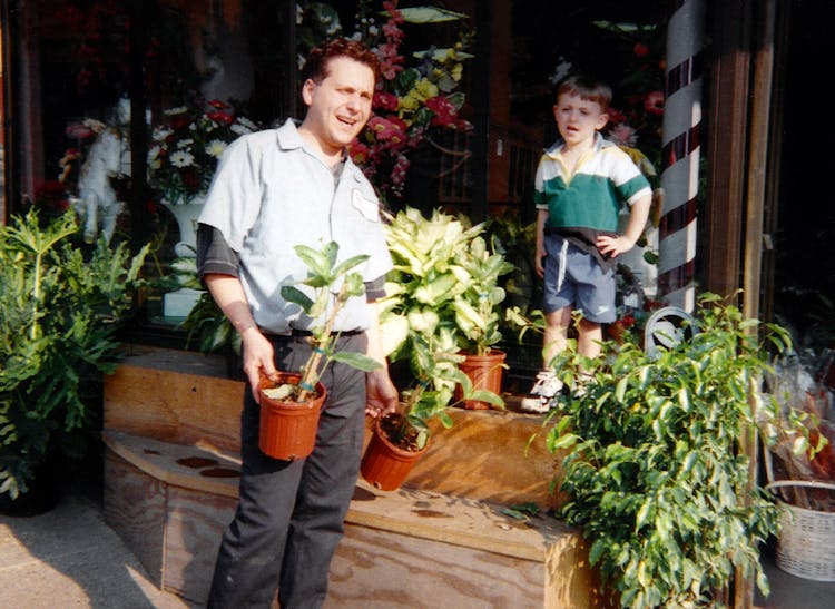 Second-generation owner, Rodney, rearranges some plants the aid of his young son, Josh
